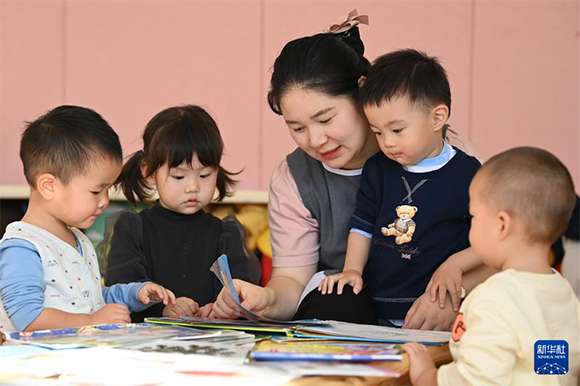在西安市未央区浐灞半岛社区，西交小雅托育中心的老师带孩子们阅读绘本（11月28日摄）。