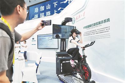 2025世界数字教育大会上，学生正在展示武汉大学研发的VR校园骑行游览展示系统。 中新社记者 张祥毅摄