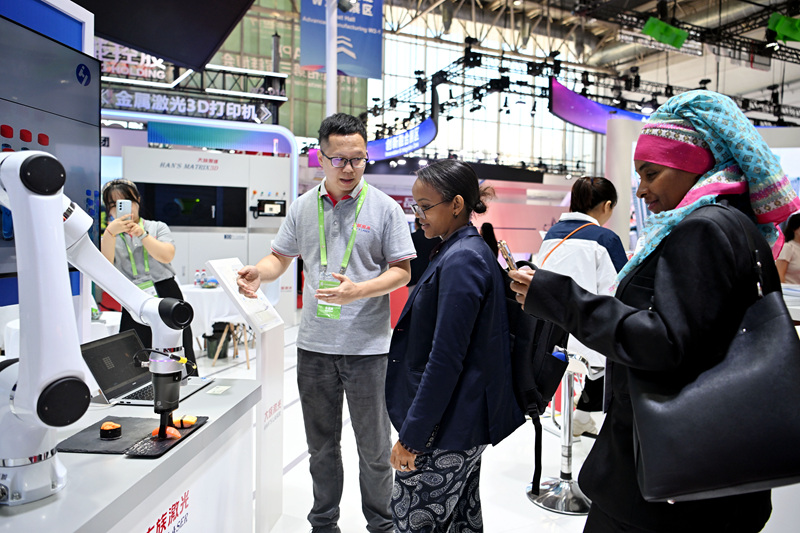 在第三届中国国际供应链促进博览会先进制造链展区，来自国外的观众正在参观协作机器人。人民网记者 翁奇羽摄