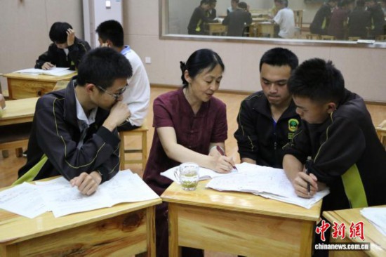 2017年5月3日，王洁(左二)正在辅导梁河一中学生。受访者 供图