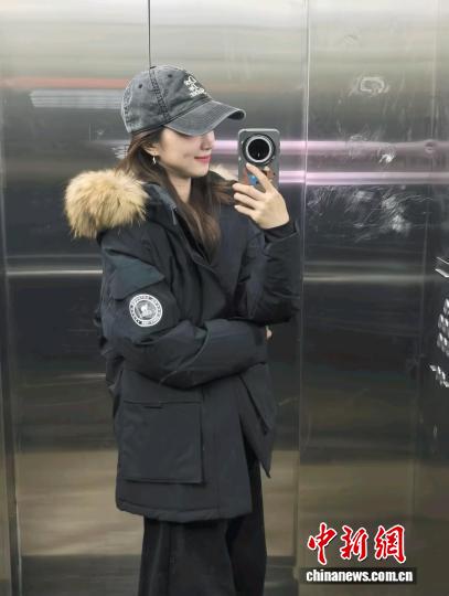 张洛齐身着今年“双十一”刚开启时买的羽绒服，这件羽绒服原价890元，折后830元买的。 受访者供图