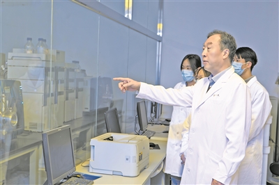 崔一民（右二）在质谱实验室指导学生开展实验。  受访者供图