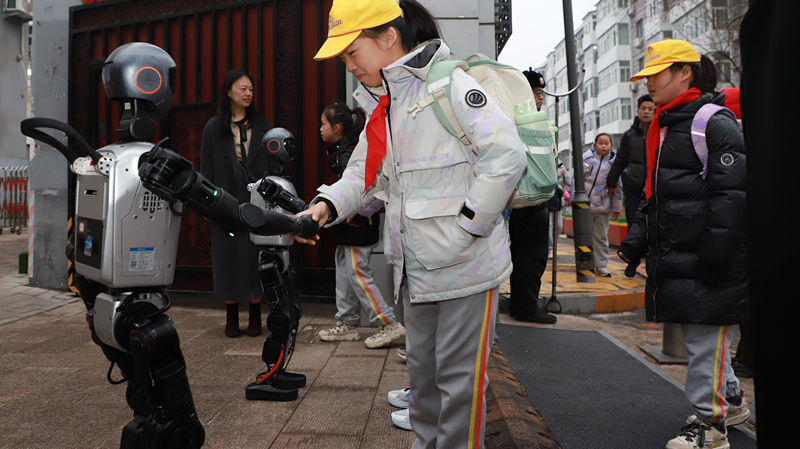 北京市东交民巷小学机器人在学校门口热情迎接同学们返校。校方供图