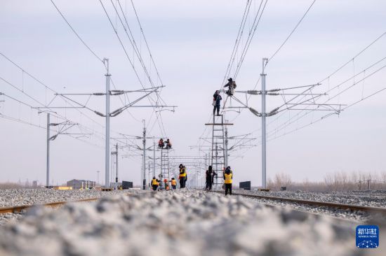 3月13日,工人在哈伊高铁绥化南站施工现场进行接触网作业。