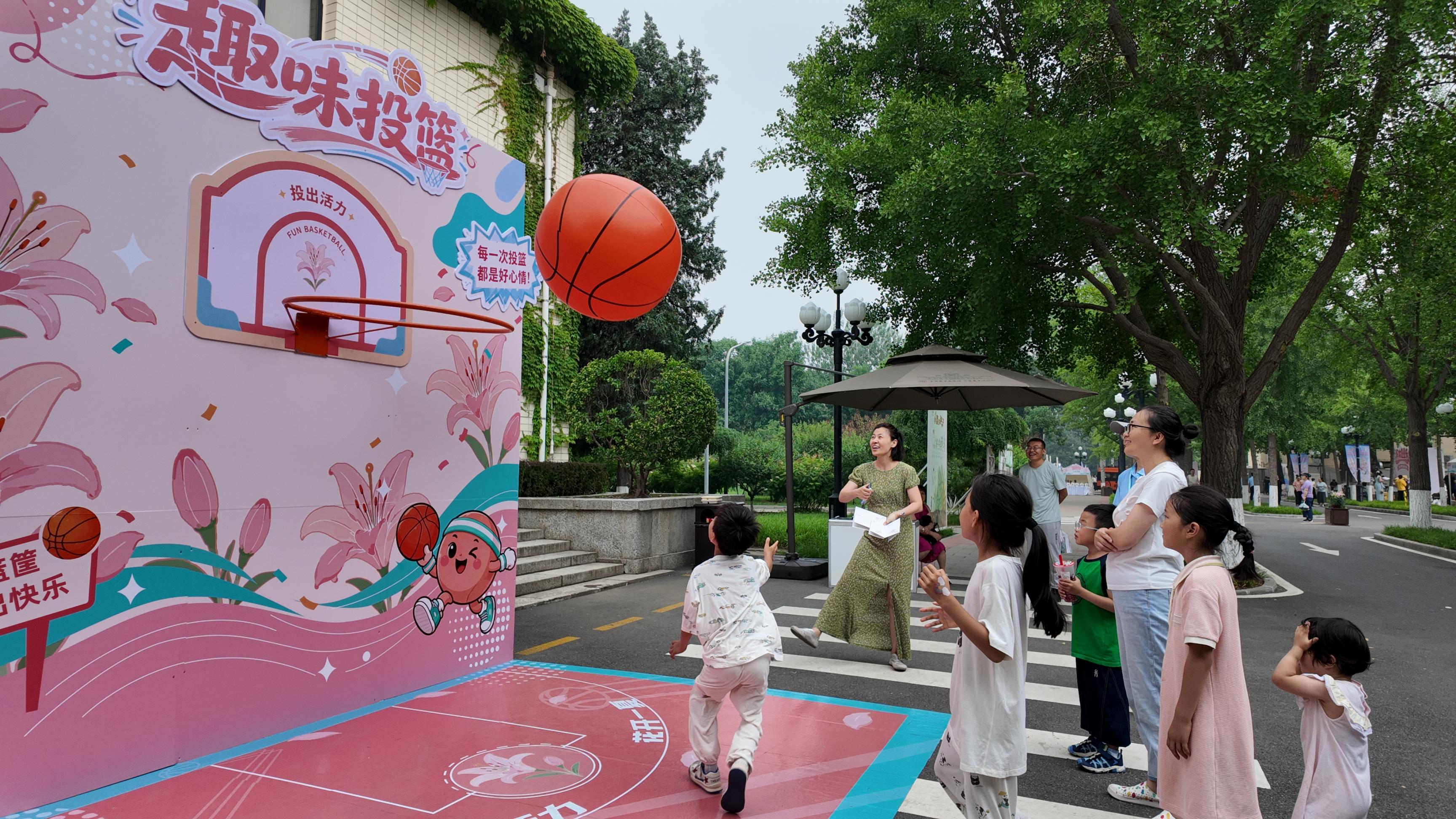 百合花节现场，孩子们正在趣味投篮。人民网记者 欧阳易佳摄