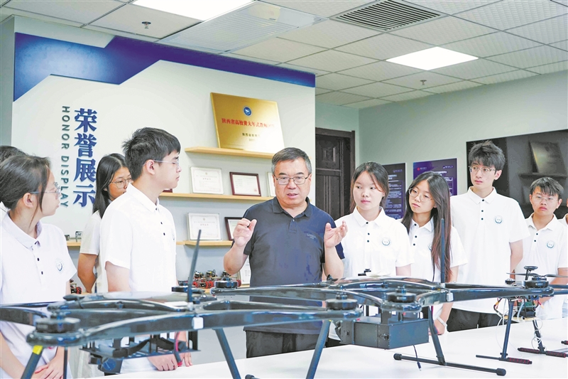 西安电子科技大学教授马建峰（中）与学生交流。 受访单位供图