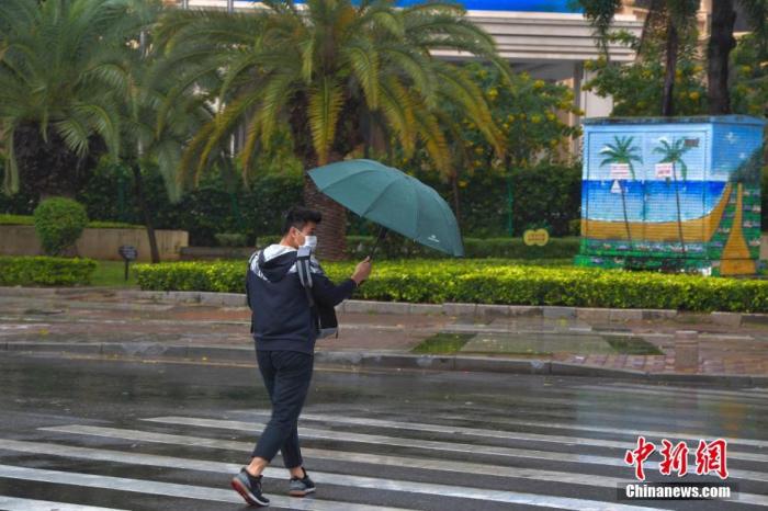 资料图：一行人冒雨出行。<a target='_blank' href='http://www.chinanews.com/'>中新社</a>记者 骆云飞 摄