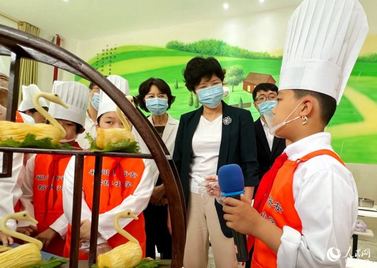 学生向参观嘉宾介绍自己和爸爸一起做的菜。人民网 郑窈摄