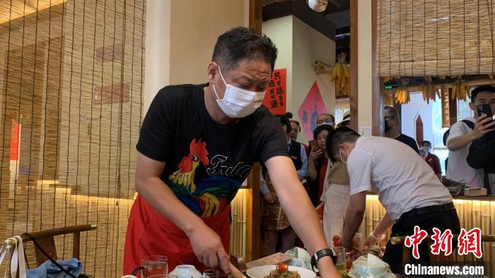 赵亮现场给食客展示如何炒制一锅美味的柴火鸡。　何浠 摄