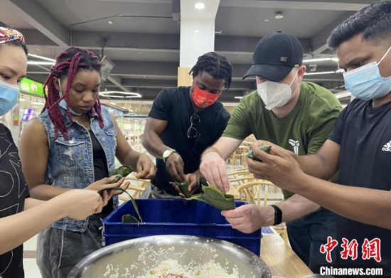 图为留学生们尝试包粽子。 张婧璇 摄