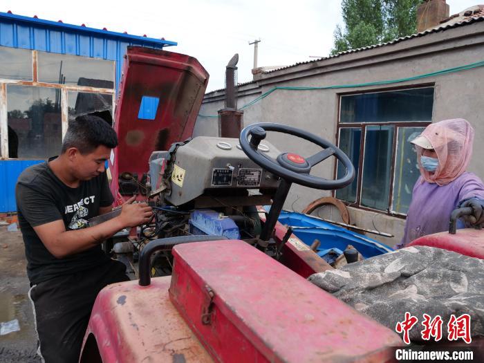 图为张云侠和儿子为顾客修车。　杨景欣 摄