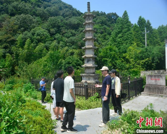 老白(右二)为乡村运营体验师介绍洪村文旅资源。　孙新尖 摄