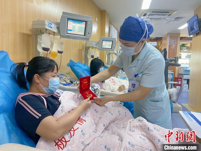 小学语文老师韦坚获授“献血百次纪念章”。　南宁市献血办供图