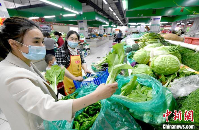 图为拉萨市民在农贸市场内选购蔬菜。　李林 摄