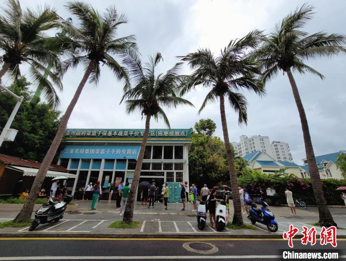 在三亚一非高、中风险区，市民游客在应急投放点前排队购买物质。　王晓斌 摄