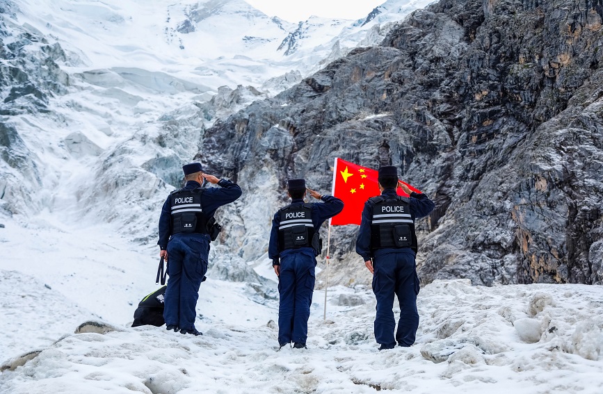 民警到达巡逻指定的地点后,向国旗进行敬礼。新疆出入境边防检查总站伊犁边境管理支队洪土沟边境检查站供图