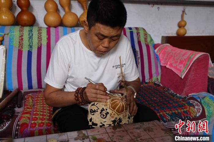 冯计刚在雕刻葫芦作品。 孔飞 摄 冯计刚在雕刻葫芦作品。 孔飞 摄