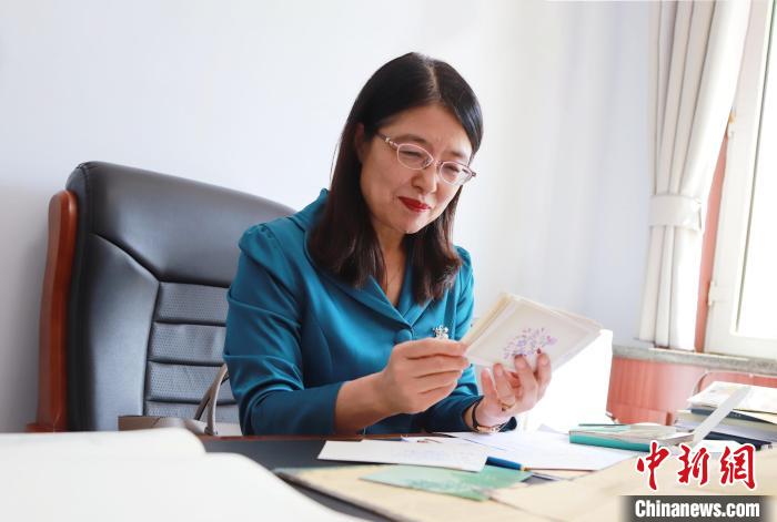 图为于秀娟读学生的赠言贺卡。　陈先达 　摄