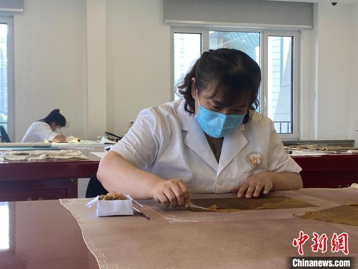 工作人员进行书画修复工作。 李明芮 摄 工作人员进行书画修复工作。 李明芮 摄