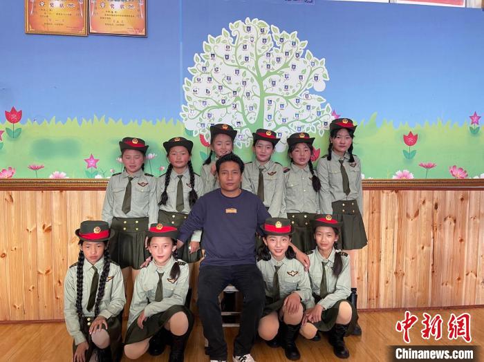 图为才文(第一排中)与学生合影。　玉树市委宣传部供图