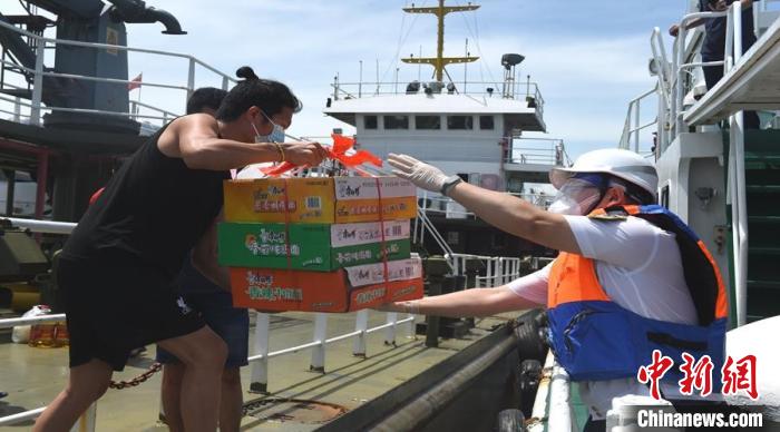 图为施小雷(右一)在疫情期间帮助船方运送物资。 洋浦海事局供图 图为施小雷(右一)在疫情期间帮助船方运送物资。 洋浦海事局供图