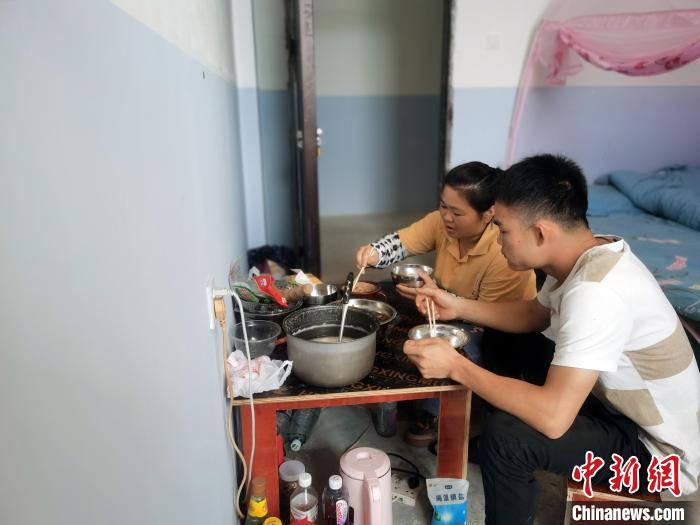 覃雪嫔和丈夫在单位宿舍共用午餐。　蒋雪林 摄