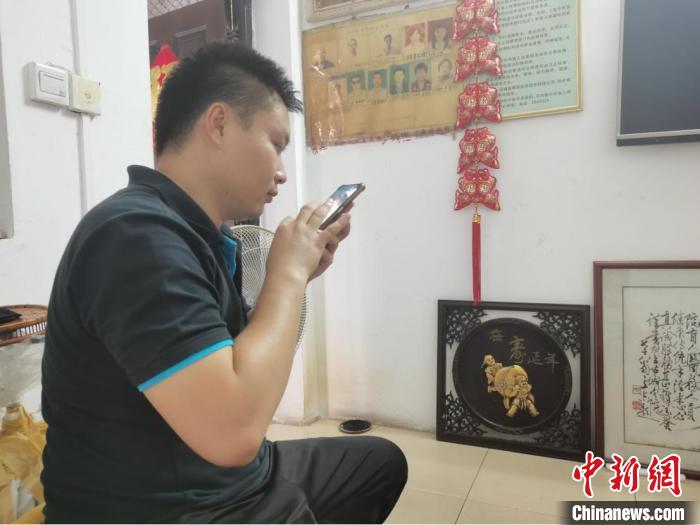 区杰杰正在使用智能手机。　牛雯莉 摄