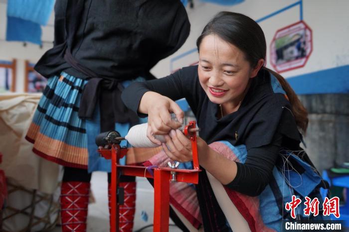 图为黎秋亿正在纺织。 韦国政 摄 图为黎秋亿正在纺织。 韦国政 摄