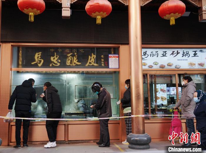 图为西宁市民在美食店前排队。　马铭言 摄