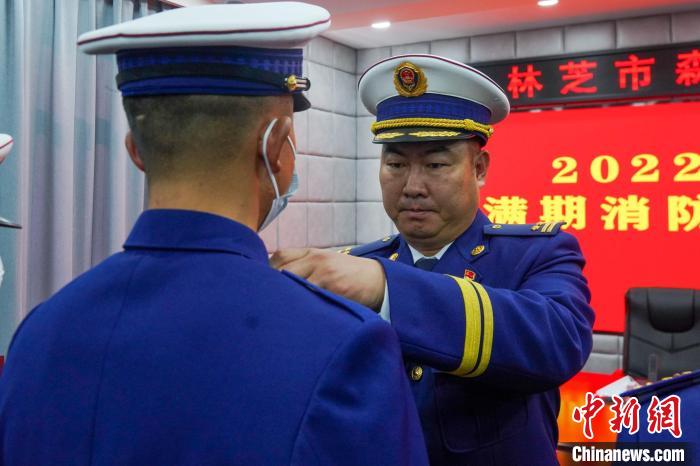 图为为退出消防员卸下肩章。 杨永龙 摄 图为为退出消防员卸下肩章。 杨永龙 摄