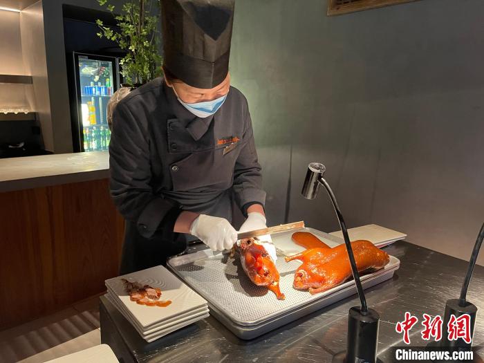一家烤鸭店内,烤鸭师傅正在“片鸭”。 潘琦 摄 一家烤鸭店内,烤鸭师傅正在“片鸭”。 潘琦 摄