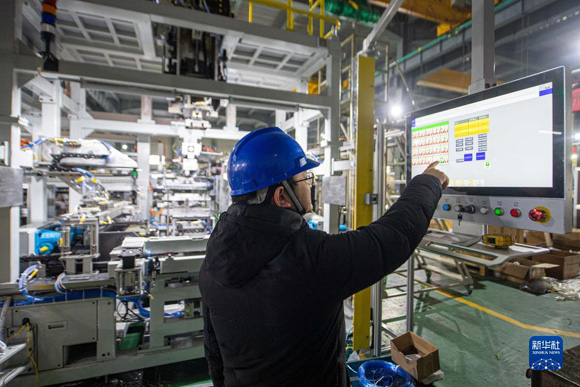 12月9日，工程师在宁波精达成形装备股份有限公司车间内调试设备。新华社记者 江汉 摄