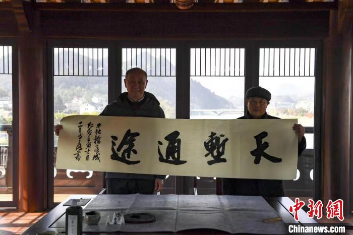 新乡贤陈经建(左)在东坡廊桥。　昌化镇 供图