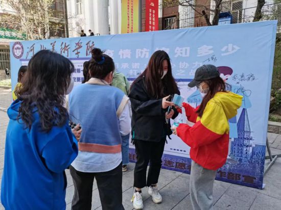 志愿者在普及疫情防控知识。 河北美术学院供图