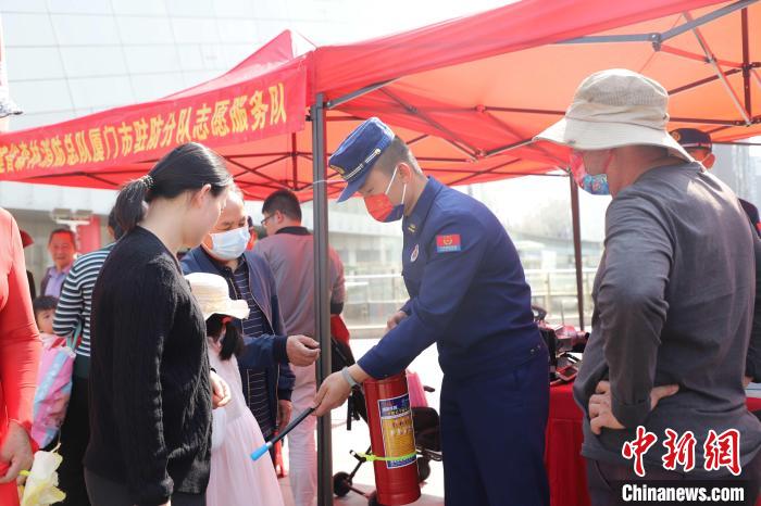 消防员在活动现场边讲解灭火机的使用技巧，边作出示范动作。　福建省森林消防总队厦门市驻防分队供图