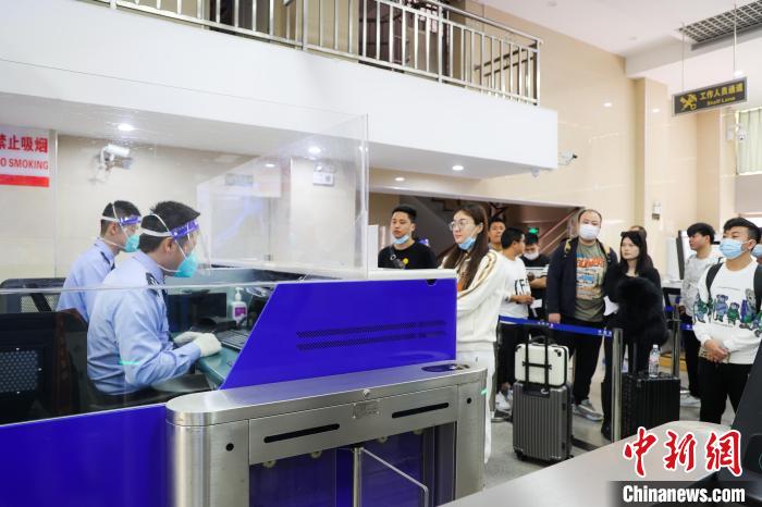 图为民警验放出入境旅客。　打洛边检站供图