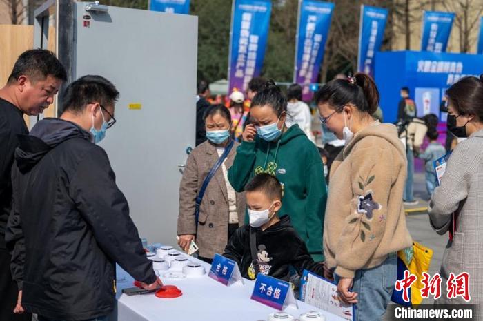 真假防火报警器鉴别吸引市民围观。　刘忠俊 摄