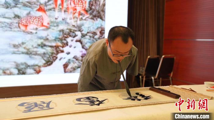 拍卖会上,无臂书法家现场创作书法作品。 中国残疾人福利基金会供图 拍卖会上,无臂书法家现场创作书法作品。 中国残疾人福利基金会供图