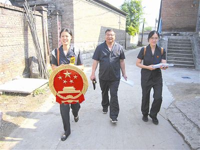 图①：干警们带着国徽赶往当事人家开庭。